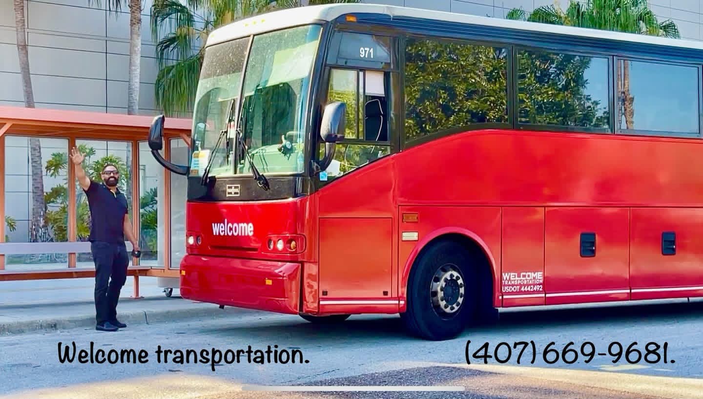 Antonio Zuluaga, founder of Welcome Transportation, waving next to one of the company's coaches